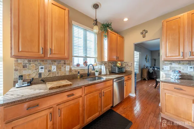a kitchen with stainless steel appliances granite countertop a sink dishwasher stove and refrigerator