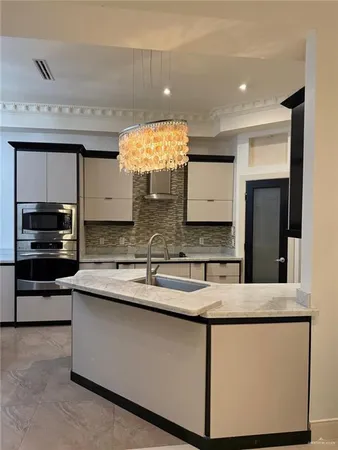 a kitchen with stainless steel appliances granite countertop a sink and a stove