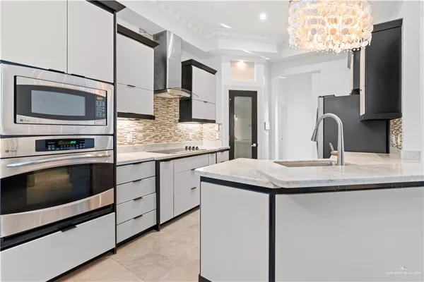 a kitchen with stainless steel appliances granite countertop a sink microwave and cabinets