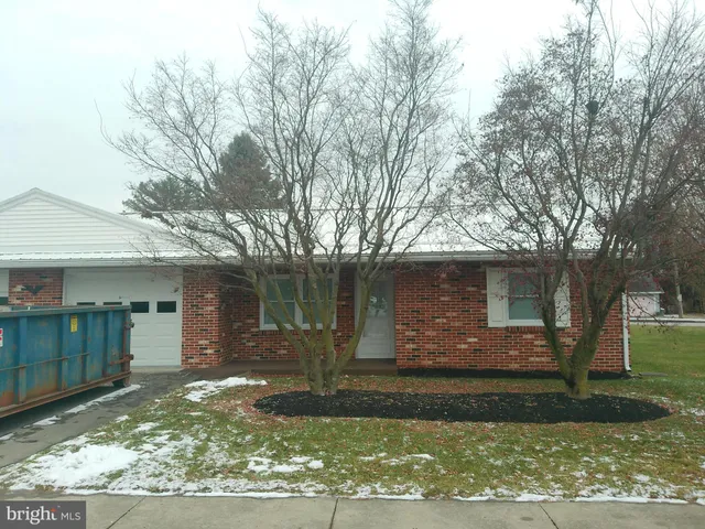a view of a yard in front of a house with large tree