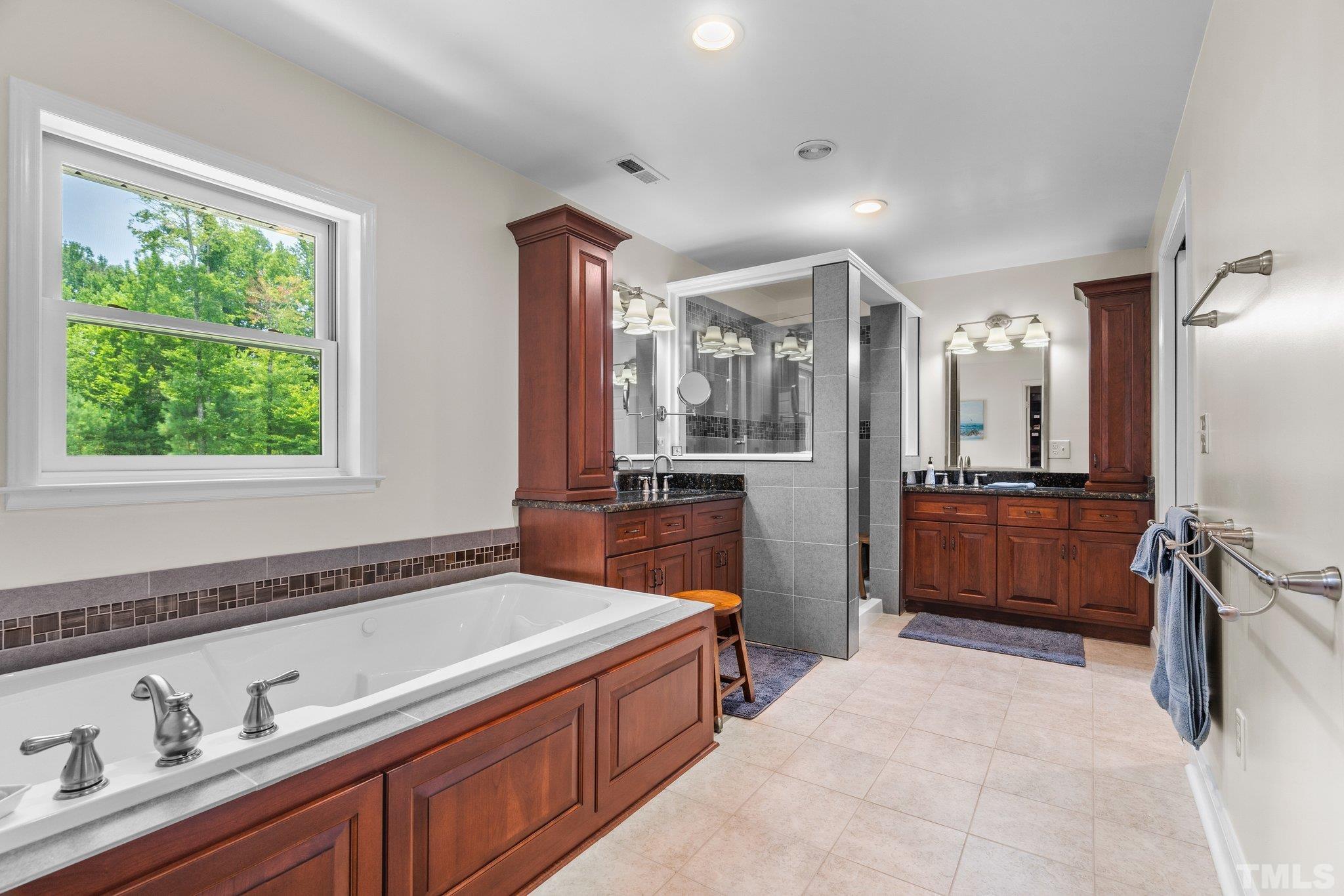5012 Payton Drive Rougemont, NC 27572 - Photo 20 of 47 a spacious en suite bathroom with a granite countertop double vanity sink a mirror and a bathtub