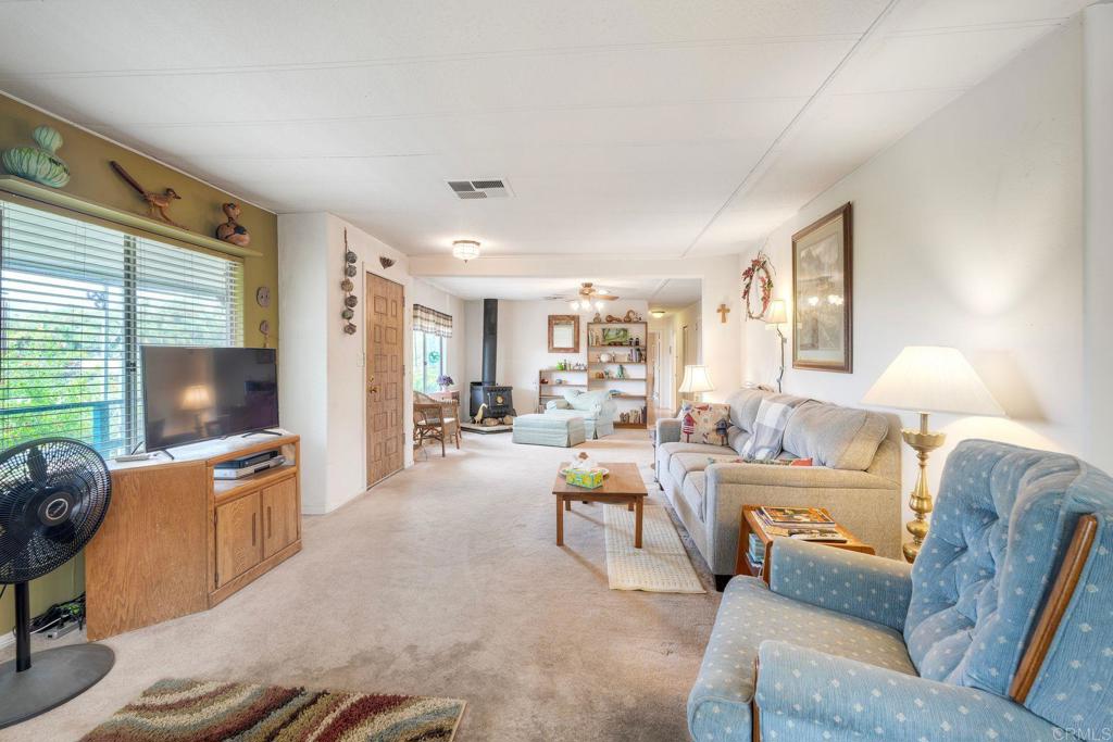 18218 Paradise Mountain Road Valley Center, CA 92082 - Photo 16 of 36 a living room with furniture and a flat screen tv