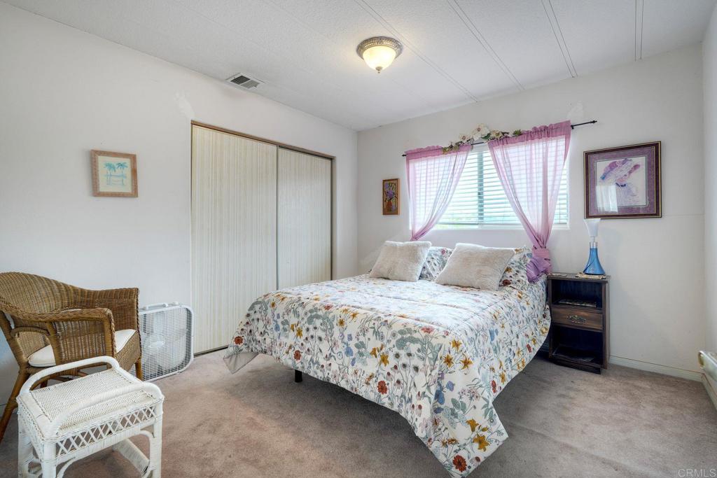 18218 Paradise Mountain Road Valley Center, CA 92082 - Photo 21 of 36 a bedroom with a bed and a chair