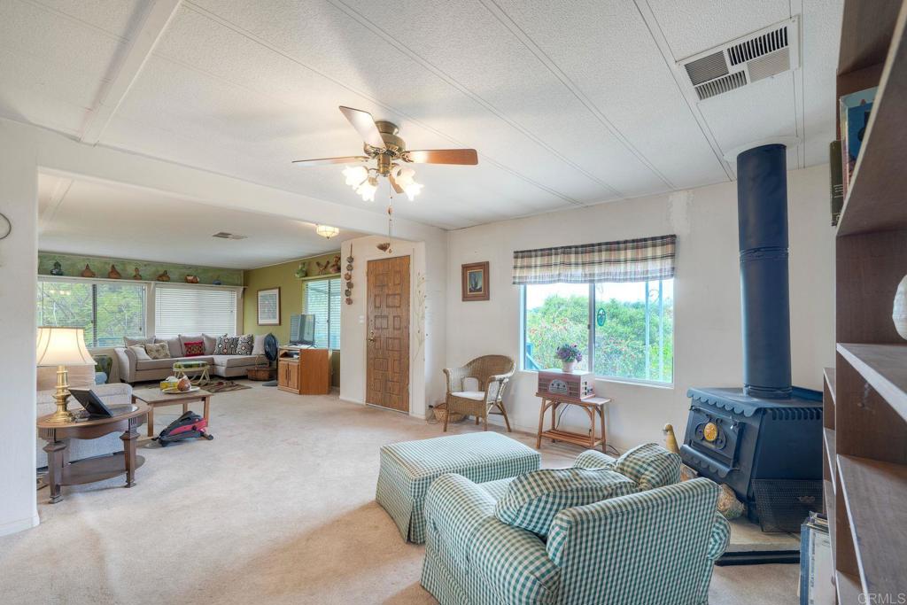 18218 Paradise Mountain Road Valley Center, CA 92082 - Photo 9 of 36 a living room with furniture fireplace and a large window