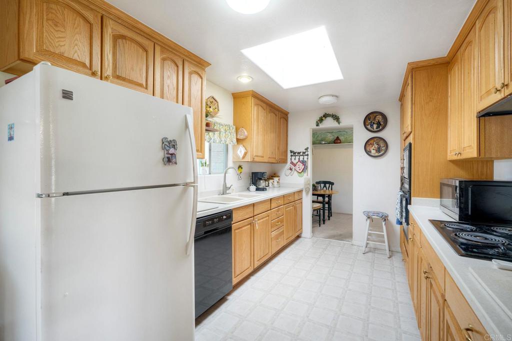 18218 Paradise Mountain Road Valley Center, CA 92082 - Photo 10 of 36 a kitchen with stainless steel appliances a refrigerator a sink a stove and white cabinets
