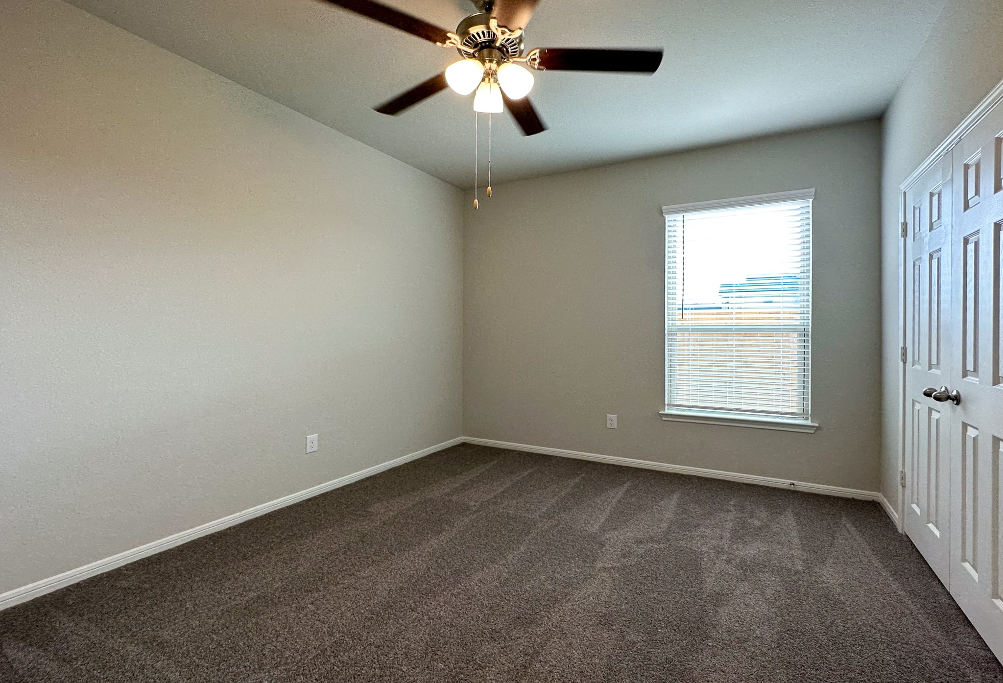27079 Badger Way Magnolia, TX 77354 - Photo 28 of 40 en empty room with windows and chandelier fan