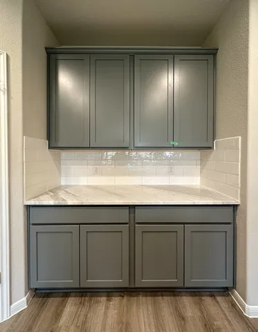 a kitchen with granite countertop cabinets and wooden floor