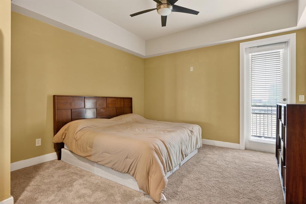 5055 Addison Circle, Unit 713 Addison, TX 75001 - Photo 14 of 40 a bedroom with a bed and a ceiling fan