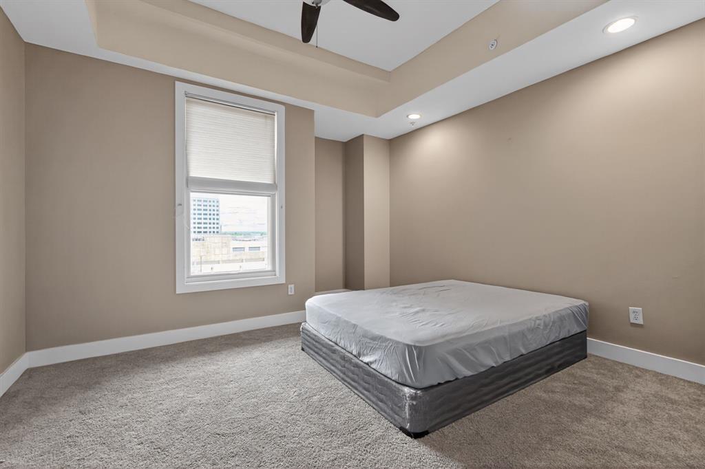 5055 Addison Circle, Unit 713 Addison, TX 75001 - Photo 16 of 40 a spacious bedroom with a bed and window