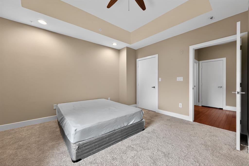 5055 Addison Circle, Unit 713 Addison, TX 75001 - Photo 17 of 40 a spacious bedroom with a bed and a chandelier