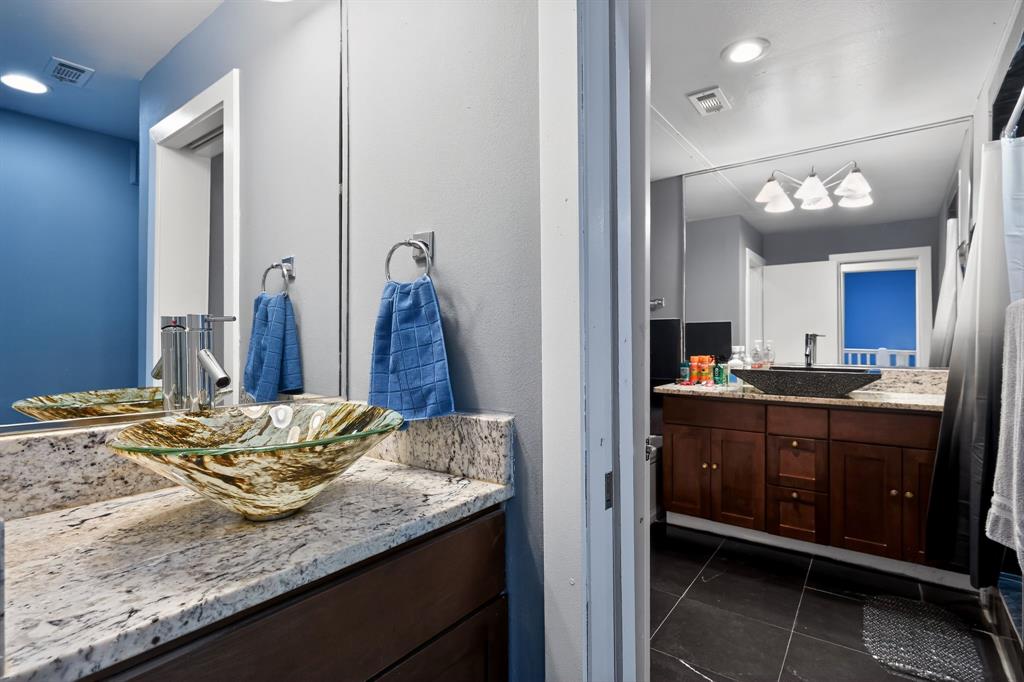 5055 Addison Circle, Unit 713 Addison, TX 75001 - Photo 19 of 40 Bathroom featuring a glass vessel sink, stone countertop, wood vanity, and a large wall-mounted mirror