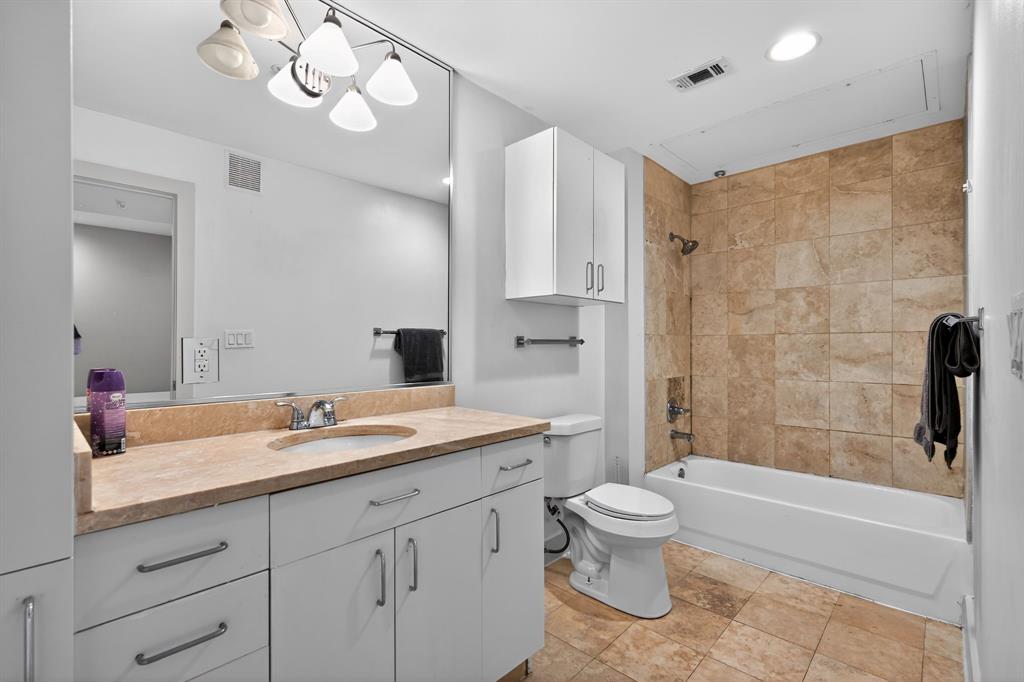 5055 Addison Circle, Unit 713 Addison, TX 75001 - Photo 20 of 40 a bathroom with a sink a toilet and a large mirror