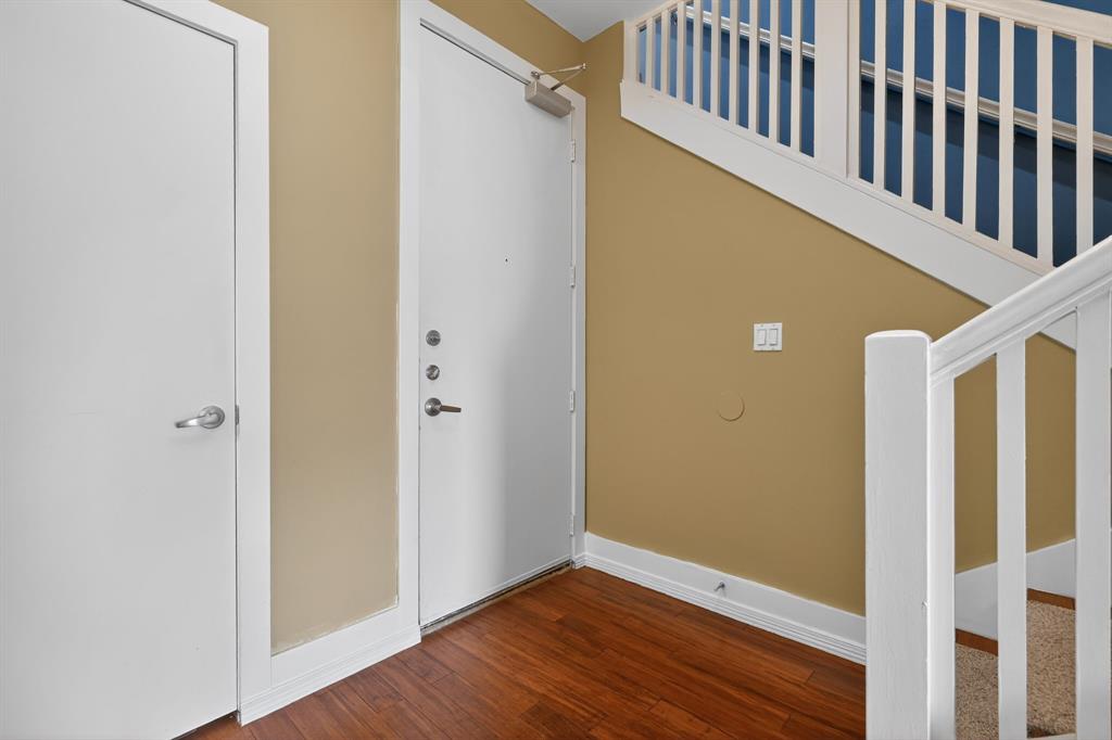 5055 Addison Circle, Unit 713 Addison, TX 75001 - Photo 24 of 40 Entryway featuring wood-finish flooring, white painted baseboards, and a staircase with white balusters