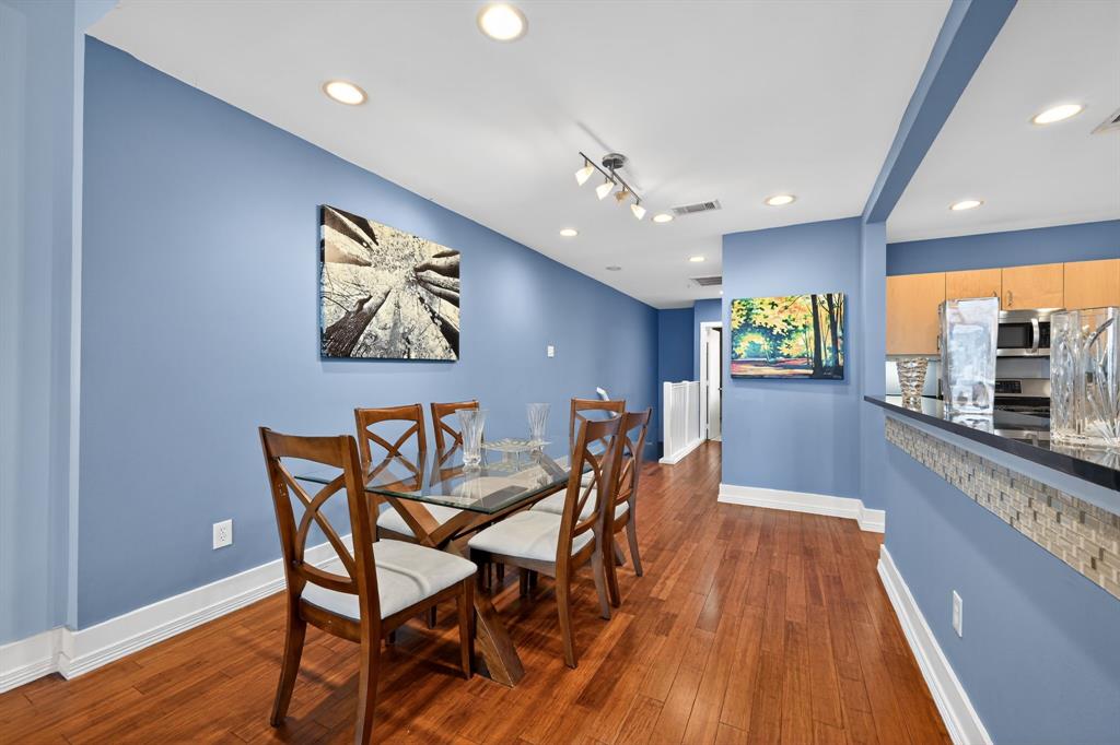 5055 Addison Circle, Unit 713 Addison, TX 75001 - Photo 10 of 40 Dining area featuring wood-finish flooring, recessed lighting, and a built-in breakfast bar with a mosaic tile accent