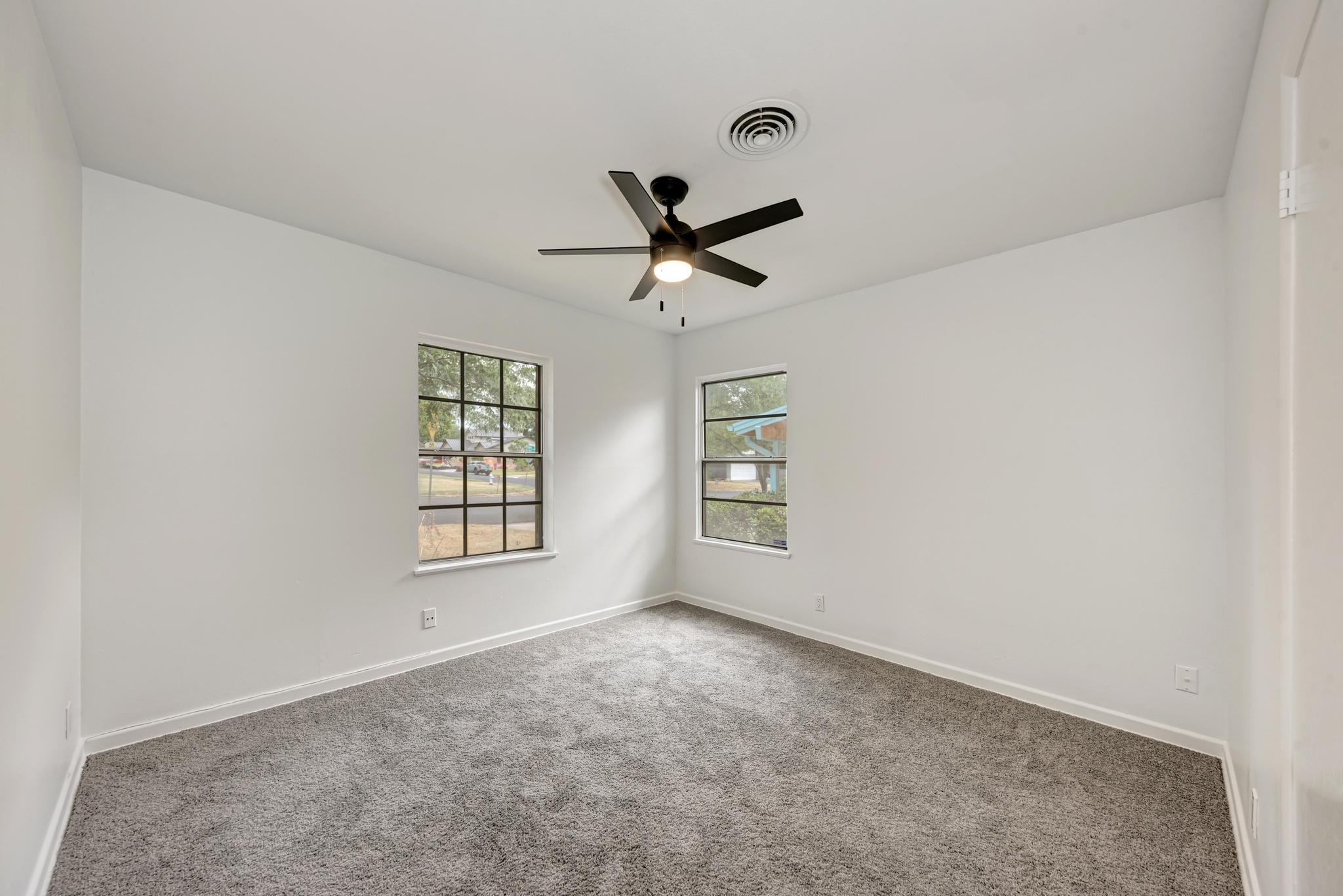 7804 Rutgers Avenue Austin, TX 78757 - Photo 17 of 32 Plush carpeting and dual windows define this serene bedroom space.