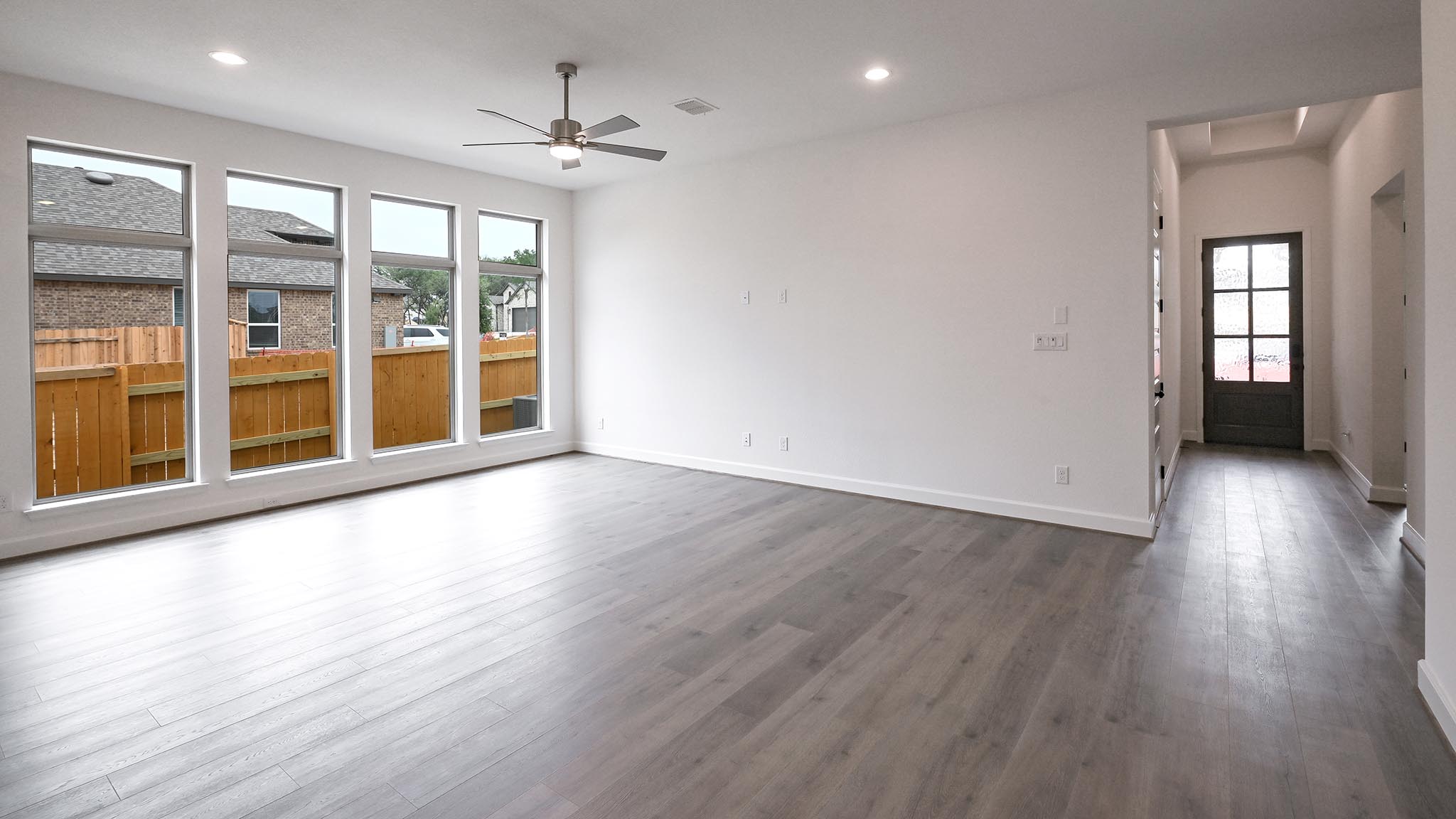 268 Basket Flower Loop Kyle, TX 78640 - Photo 20 of 27 an empty room with wooden floor and a ceiling fan