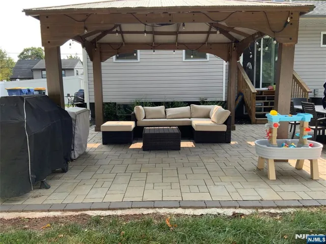 a view of a patio with couches table and chairs under an umbrella