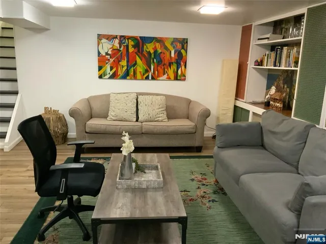 a living room with furniture and a book shelf