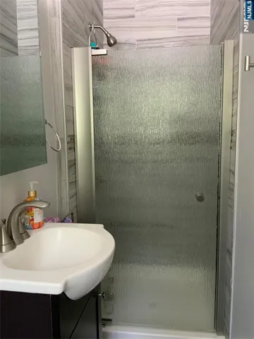 a bathroom with a sink shower and a mirror