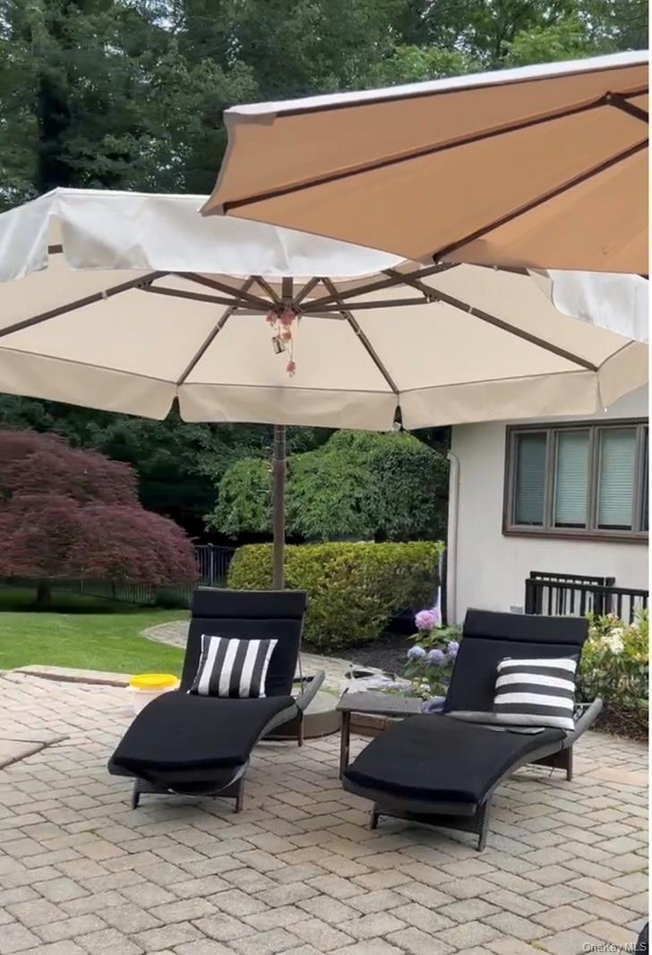 37 Bridle Path St. James, NY 11780 - Photo 35 of 38 a view of a patio with couches table and chairs under an umbrella