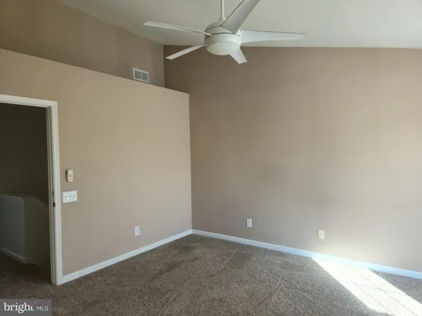 an empty room with a ceiling fan and a window