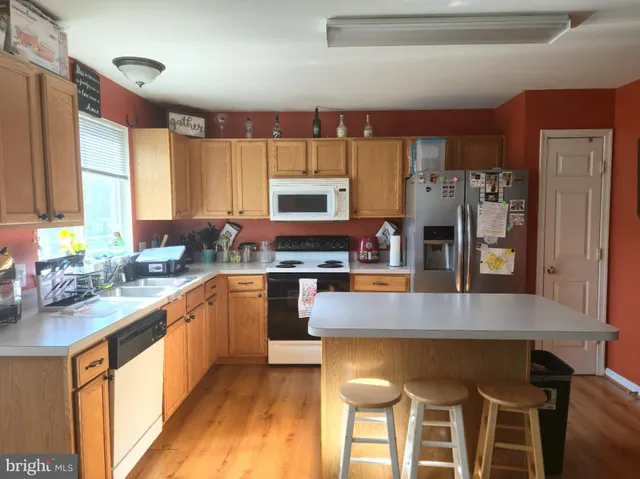a kitchen with stainless steel appliances wooden floor dining table and chairs
