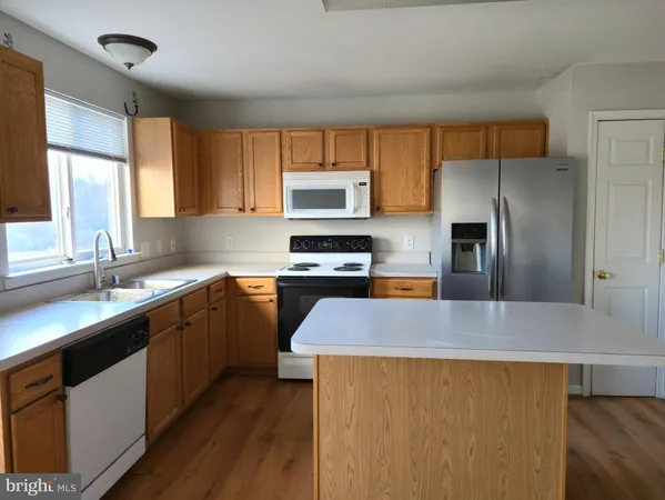 a kitchen with granite countertop a refrigerator and a sink