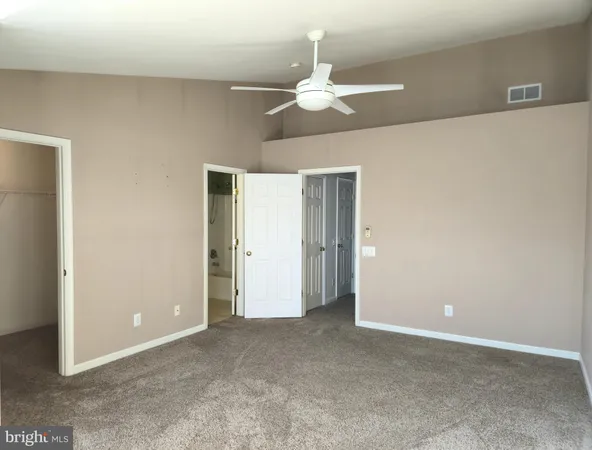 a view of an empty room with a chandelier fan