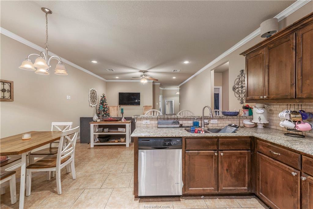 3621 Haverford Road College Station, TX 77845 - Photo 10 of 24 a kitchen with kitchen island granite countertop a sink cabinets and stainless steel appliances