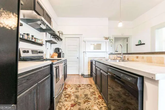 a kitchen with stainless steel appliances granite countertop a sink and a stove