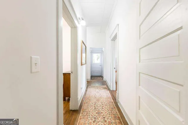 a view of a hallway with wooden floor and staircase