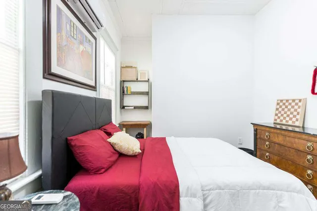 a bedroom with a large bed and a window