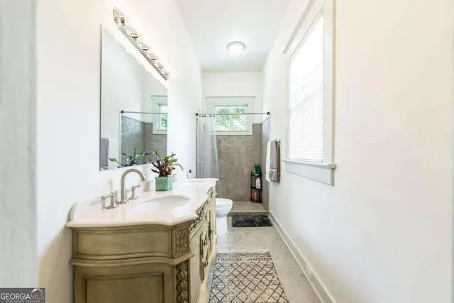 a bathroom with a sink a toilet and a mirror