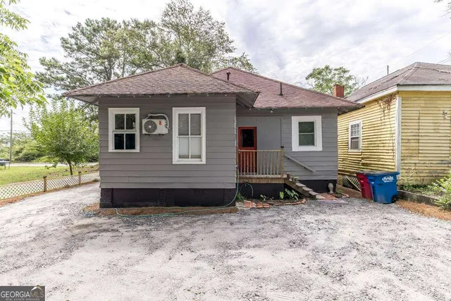 a view of a house with a yard and sitting area