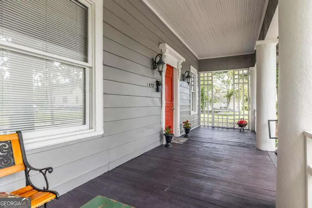 a view of an empty room with wooden floor and windows