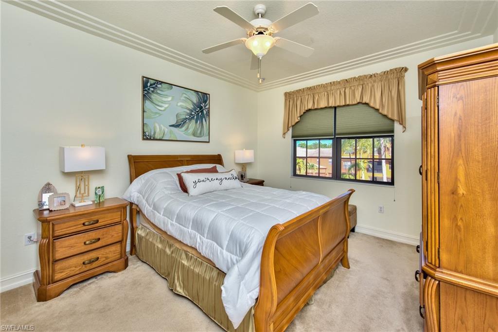 9102 Capistrano Street South, Unit 7209 Naples, FL 34113 - Photo 11 of 25 a bedroom with a bed and a chandelier