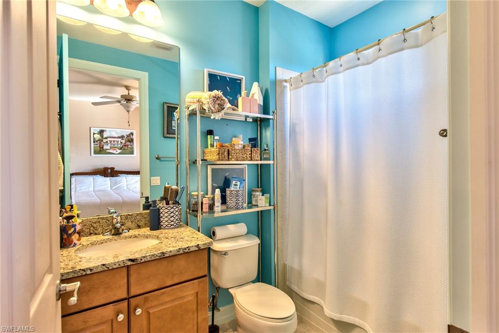 9102 Capistrano Street South, Unit 7209 Naples, FL 34113 - Photo 12 of 25 a bathroom with a granite countertop sink toilet and shower