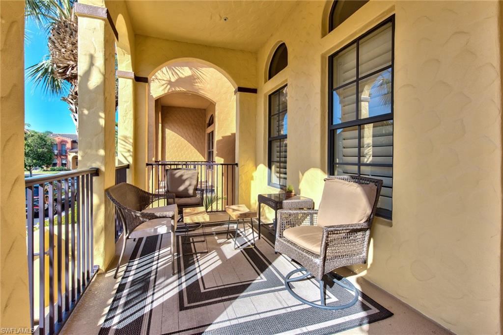 9102 Capistrano Street South, Unit 7209 Naples, FL 34113 - Photo 4 of 25 a view of a balcony with chairs and floor to ceiling window