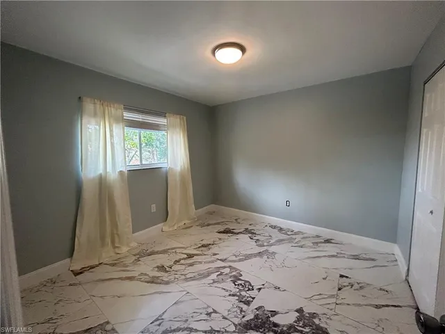 a view of a room with a bed and wooden floor