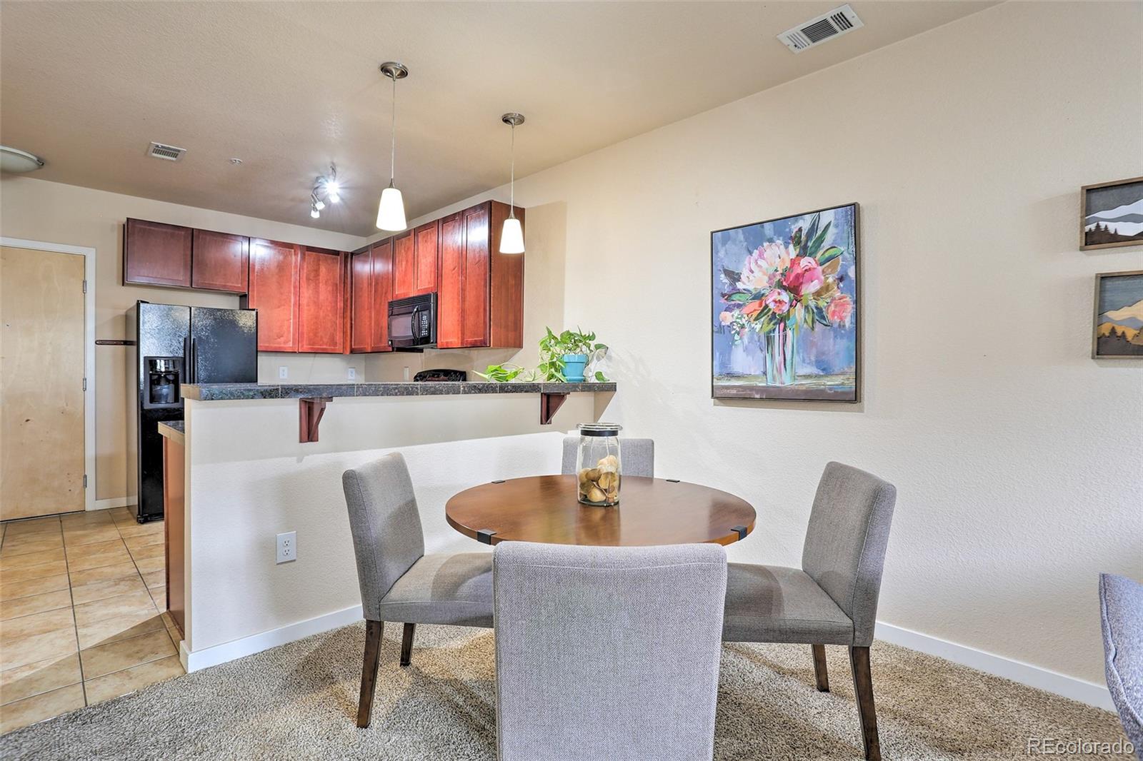 3101 Blake Street, Unit 214 Denver, CO 80205 - Photo 8 of 25 a kitchen with stainless steel appliances a dining table and chairs