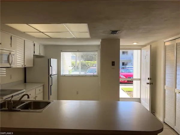 a view of a kitchen with refrigerator and a sink