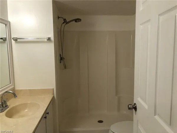 a bathroom with a granite countertop shower sink vanity and a mirror