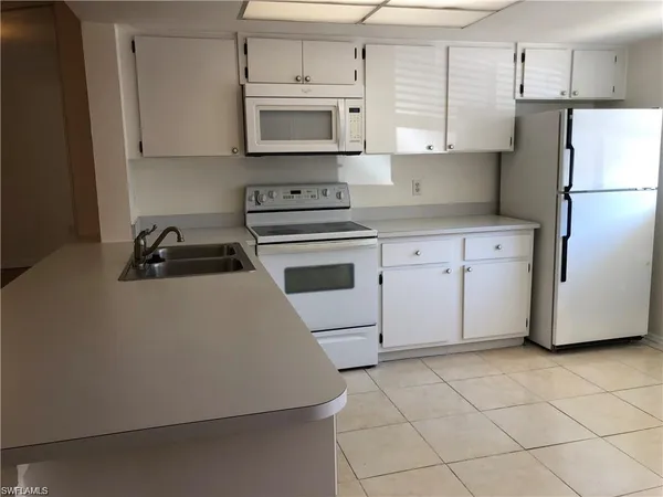 a kitchen with cabinets stainless steel appliances and a counter space