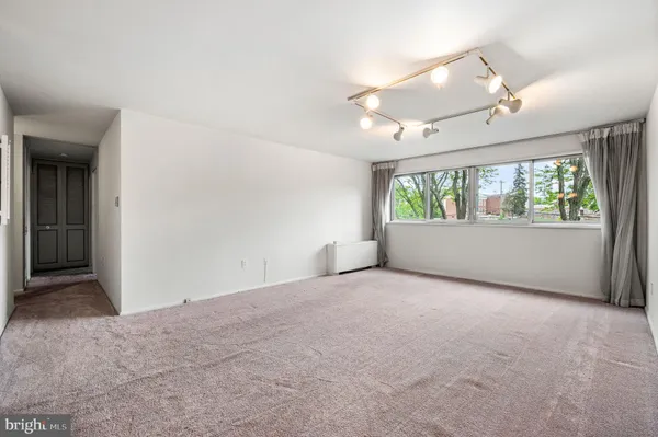 an empty room with windows and ceiling fan