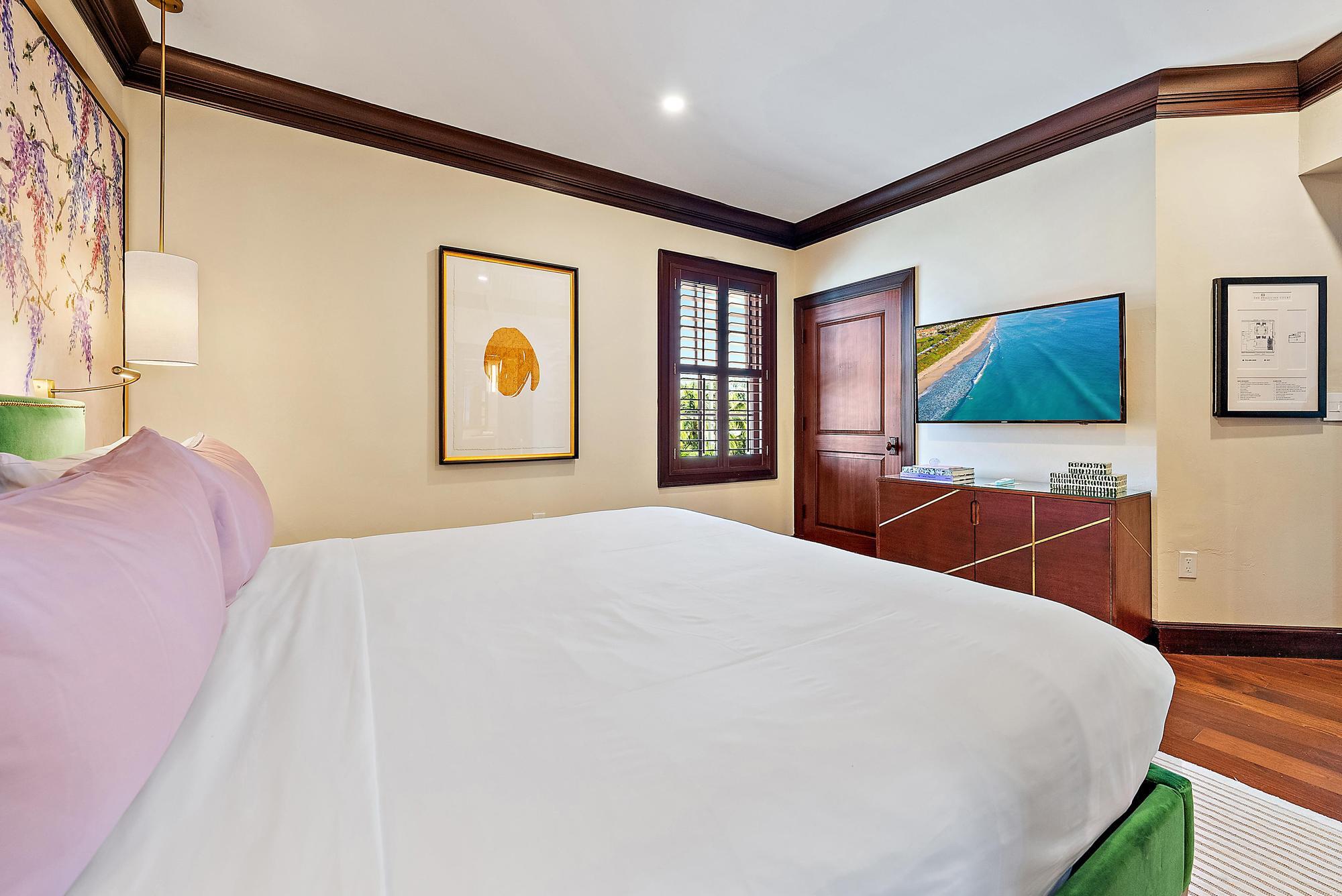 301 Australian Avenue, Unit 301 Palm Beach, FL 33480 - Photo 12 of 26 a bedroom with a large bed and a flat screen tv