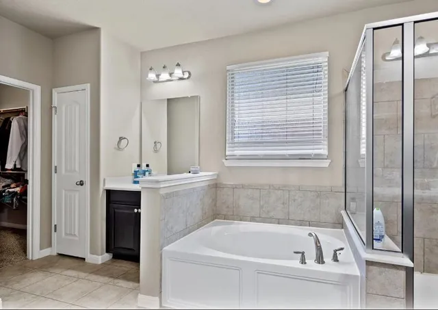 a bathroom with a bathtub a sink and a window