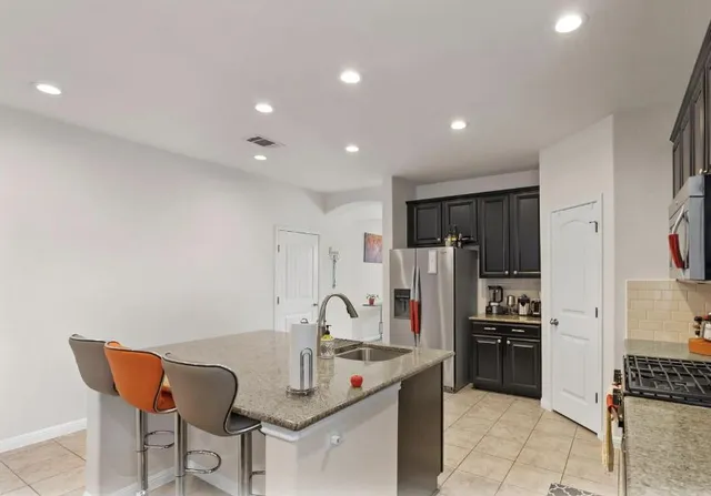 a kitchen with stainless steel appliances granite countertop a refrigerator and a stove top oven