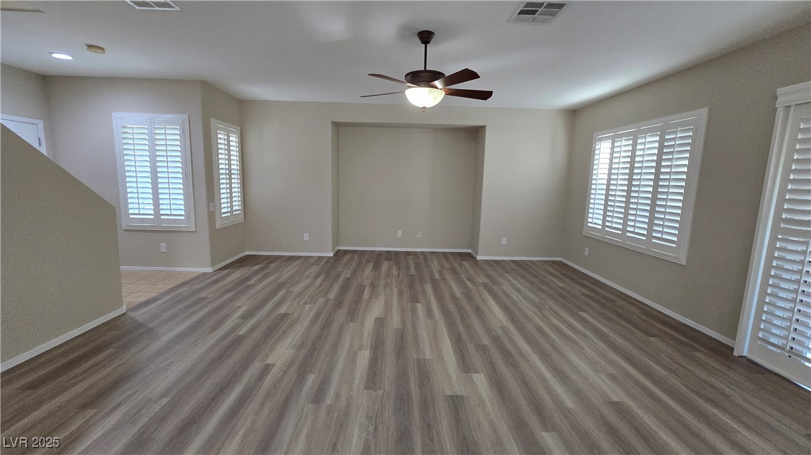 2737 Rimbaud Street Henderson, NV 89044 - Photo 7 of 49 Unfurnished living room with a ceiling fan, baseboards, visible vents, and wood finished floors