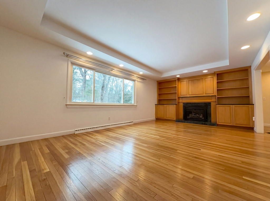 16 Crest Drive Dover, MA 02030 - Photo 3 of 24 an empty room with wooden floor fireplace and windows