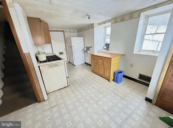 a view of a kitchen with fridge and a sink